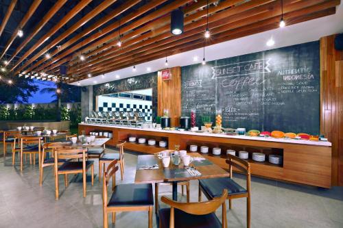 a restaurant with tables and chairs and a chalkboard at Aston Anyer Beach Hotel in Anyer