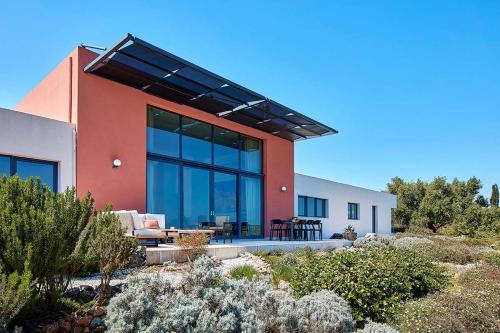 a house with a large window on the side of it at Villa The Longhouse- Pool-Sauna-Gym- Panormaic Seaview in Sellía