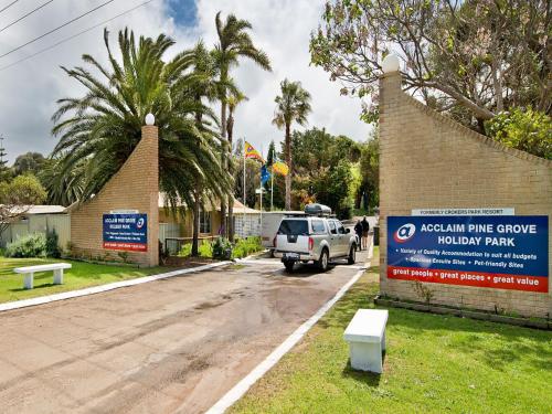 a white car driving down a road next to a sign at Acclaim Pine Grove Holiday Park in Esperance
