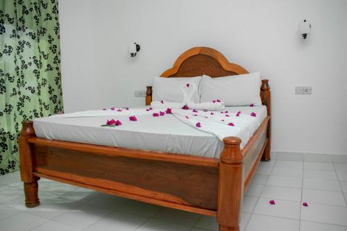 uma cama com flores num quarto em Daniel Zanzibar Hotel em Nungwi