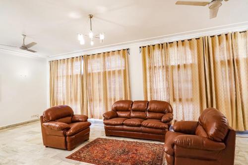 a living room with two chairs and a couch at FabExpress Goodwill Homes in New Delhi