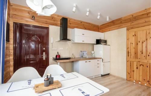 a kitchen with a table and some white cabinets at Stunning Apartment In Jaroslawiec With Wifi And 1 Bedrooms in Jarosławiec