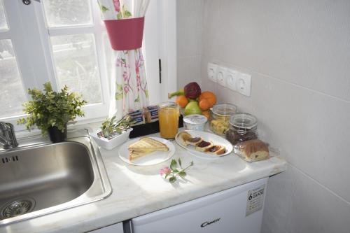 a kitchen counter with plates of food and fruit on it at Comfort Stay Athens Airport Hotel - FREE shuttle from and to the airport in Spáta