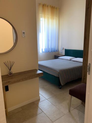 una camera con letto, specchio e sedia di B&B Mercadante a Bari