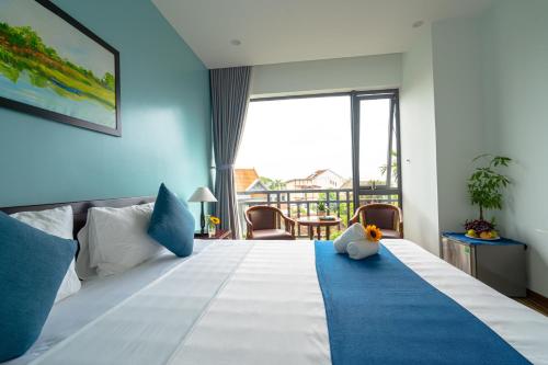 a bedroom with a large bed with a blue wall at Golden Star Villa Hoi An in Hoi An