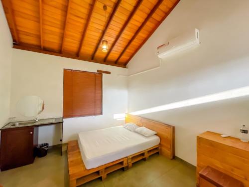 a bedroom with a bed and a wooden ceiling at Battaramulla Boutique Villa in Sri Jayewardenepura Kotte