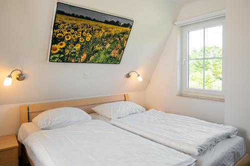 a bedroom with a bed and a painting on the wall at CLASSIC Ferienhaus Schwan A10 - a59772 in Gramkow