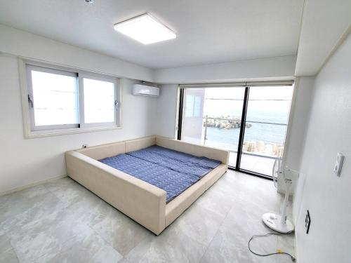 ein Schlafzimmer mit einem großen Bett in einem Zimmer mit Fenstern in der Unterkunft Storm Wind Poolvilla in Ulsan