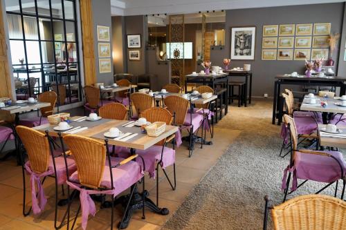 a dining room with tables and purple chairs at Hotel Prins Boudewijn in Knokke-Heist
