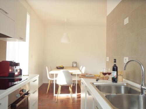 a kitchen with a sink and a table with chairs at Casa Nina in Sondrio