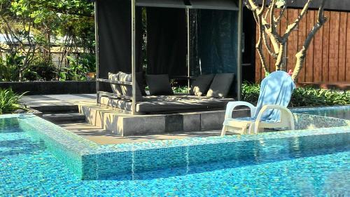 a swimming pool with two chairs next to a house at Baan Sandao Condo in Hua Hin