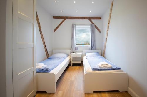 2 camas en una habitación con ventana en Ferienwohnung BEA 2 - a76069, en Rabenkirchen-Faulück