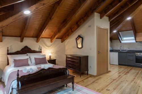 a bedroom with a large bed and a wooden ceiling at Casa dos Mortágua in Fermelã