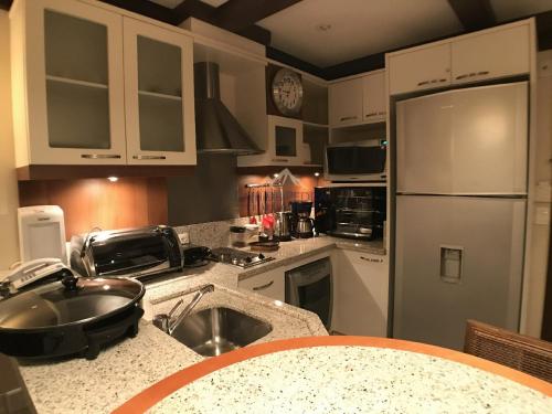 a kitchen with a sink and a refrigerator at Laje de Pedra Mountain VillagePrime in Canela