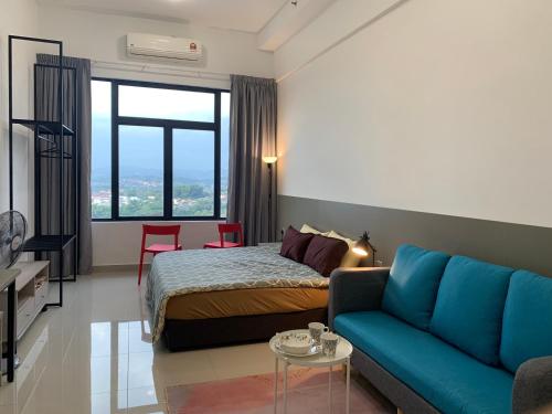 um quarto com uma cama e um sofá azul em David Studio Unicity, Seremban 3 em Seremban
