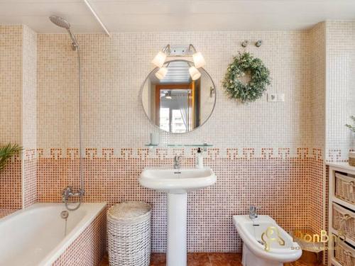 a bathroom with a sink and a tub and a mirror at Apartment with pool and private parking near Aqua Mijas in Fuengirola