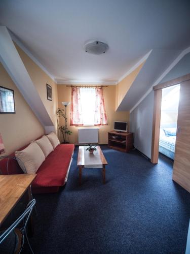 a living room with a couch and a table at Hotel Holzbecher Ratibořice in Česká Skalice