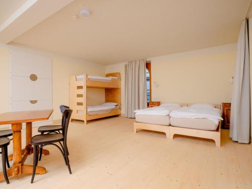 a bedroom with two beds and a desk and a table at Grand Hotel du Cervin - Auberge de jeunesse wellness in Saint-Luc
