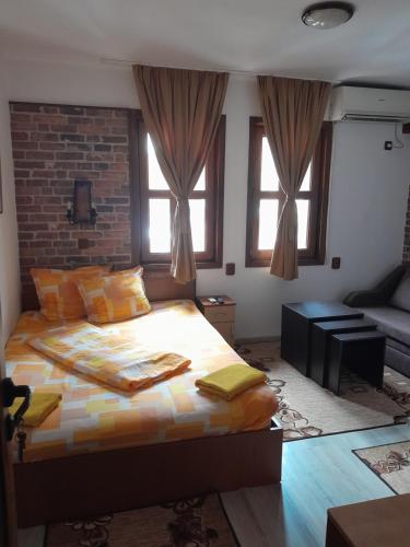 a bedroom with a bed and a brick wall at Mario Complex in Melnik