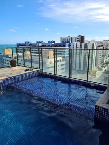 a swimming pool on the roof of a building at Grande Apartamento Beira-Mar 2/4 Pajuçara in Maceió