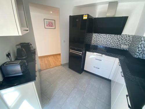 a kitchen with a black refrigerator and a tile floor at Riviera Eden Palace in Cannes