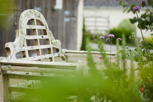 a white bench sitting in a garden with flowers at Sid Valley Country House Hotel in Sidmouth
