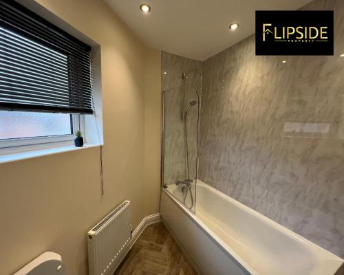 a bathroom with a shower and a bath tub at Three Bedroom Semi Detached House By Flipside Property Aylesbury Serviced Accommodation & Short Lets With Wifi & Parking in Aylesbury