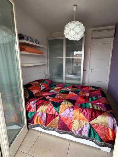a bedroom with a colorful quilt on a bed at RICCIO BLU pochi passi dal mare in Alba Adriatica