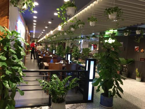 a restaurant with tables and potted plants at Gold Coast Luxury Apartment Nha Trang in Nha Trang