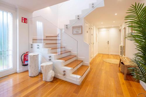 - un escalier blanc dans une chambre dotée de parquet dans l'établissement Bista Eder Hotel & Lodge, à Fontarrabie