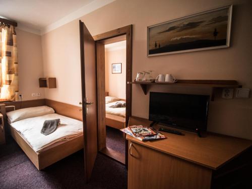 Pokój hotelowy z sypialnią z łóżkiem i lustrem w obiekcie Hotel Holzbecher Ratibořice w mieście Česká Skalice