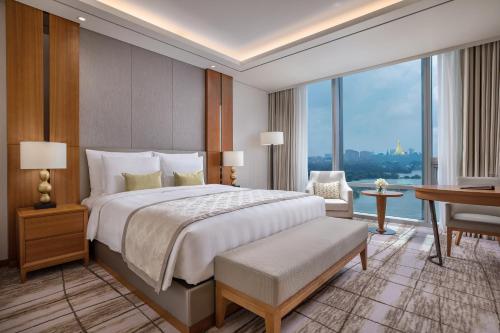 a bedroom with a large bed and a desk and a desk at LOTTE Hotel Yangon in Yangon