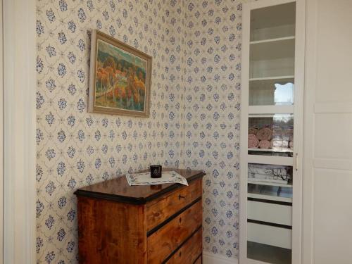 a room with a dresser and a painting on a wall at Wallinshuset in Sunne
