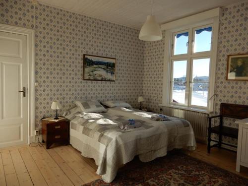 ein Schlafzimmer mit einem großen Bett und einem Fenster in der Unterkunft Wallinshuset in Sunne