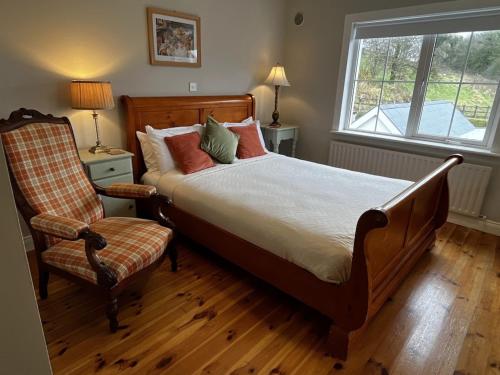 1 dormitorio con 1 cama, 1 silla y 1 ventana en Living Waters Retreat en Donegal