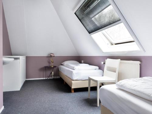 a attic bedroom with two beds and a skylight at Bungalow near De Alde Feanen with Spa in Earnewâld