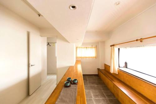 a living room with a bench and a window at Osaka SENJU big Tatami house Max 16ppl direct to KIX airport in Osaka