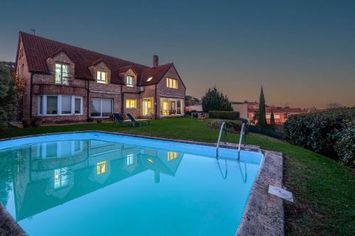 una casa con piscina frente a una casa en Bista Eder Hotel & Lodge, en Hondarribia
