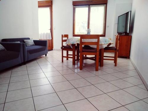 a living room with a couch and a table and a tv at L'Embrun de la Baie de Somme in Saint-Valery-sur-Somme