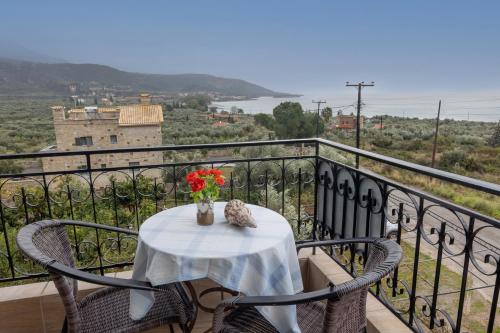 a table with a vase of flowers on a balcony at Paradeisos in Kardamili