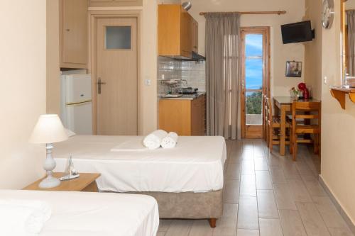 a hotel room with two beds and a kitchen at Paradeisos in Kardamyli