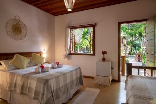 Cottage Bahia في ارايال دايودا: غرفة نوم بسرير ونافذة