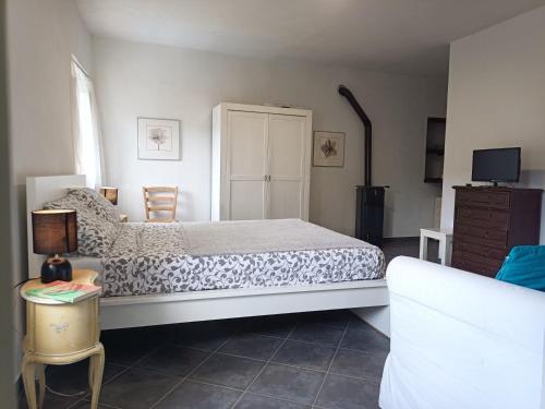 1 dormitorio con 1 cama, TV y sofá en B&B Sant'Anna, en Cairo Montenotte