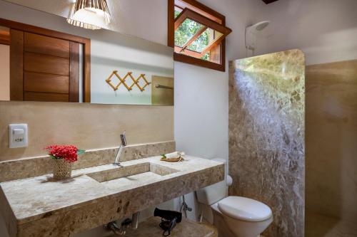 La salle de bains est pourvue d'un lavabo et de toilettes. dans l'établissement Cottage Bahia, à Arraial d'Ajuda