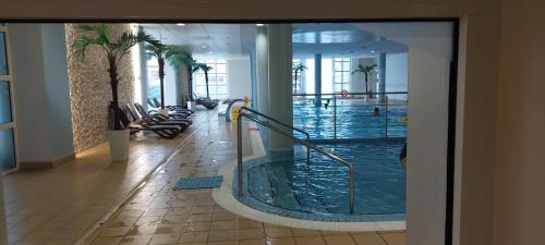 a large swimming pool in a building with a lobby at Apartament 2 pokojowy prywatny z aneksem kuchennym w hotelu Diva in Kołobrzeg