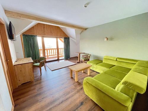 sala de estar con sofá verde y mesa en Pensiunea Coronita, en Vişeu de Sus