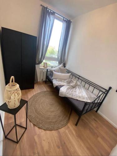 a bedroom with a bed and a table and a window at Südstrand nahe Eigentumswohnung mit Stil in Wilhelmshaven