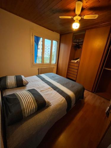 1 dormitorio con cama y ventana en appartement fond de jardin 1 étage, en Palaiseau