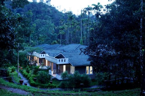 a house in the middle of a forest at Nexstay Lakkidi Village Resort in Vythiri