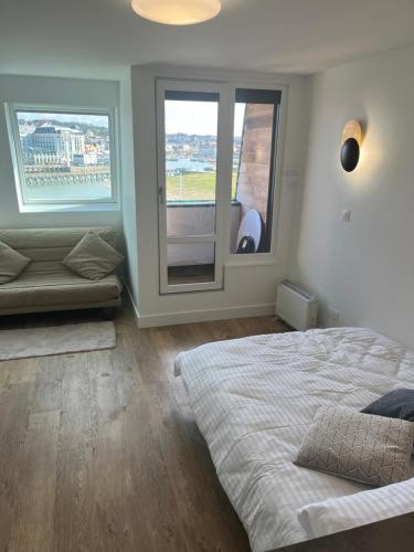 sypialnia z dużym łóżkiem i oknem w obiekcie Mon balcon face à la mer - les Marinas Deauville w mieście Deauville
